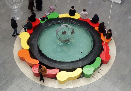 скамьи из стеклопластика вокруг фонтана в интерьере торгово-развлекательного комплекса